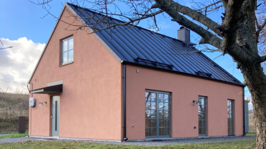 Bild på ett rosa hus under hösten